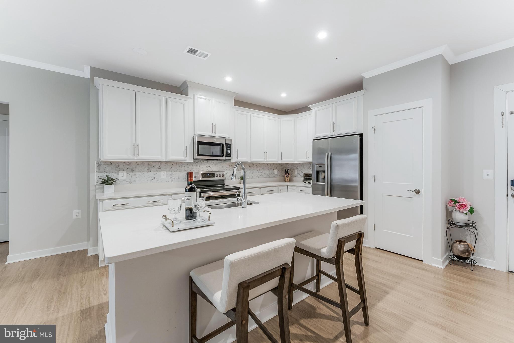 1675 Bandit Loop, Unit 105B Reston, VA 20190 - Photo 5 of 27 a kitchen with stainless steel appliances a refrigerator stove microwave and cabinets