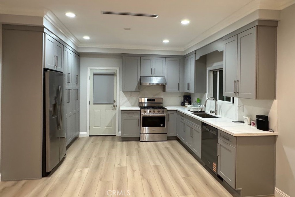 500 North Resh Place, Unit B Anaheim, CA 92805 - Photo 1 of 14 a large kitchen with a large counter top a sink stainless steel appliances and cabinets