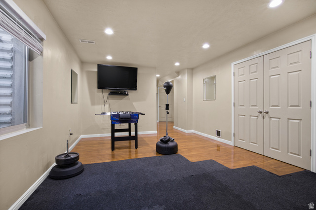 2005 Redtail Way Layton, UT 84040 - Photo 18 of 37 Lower-level room featuring recessed lighting, a window with blinds, wood-finish flooring, and a wall-mounted television