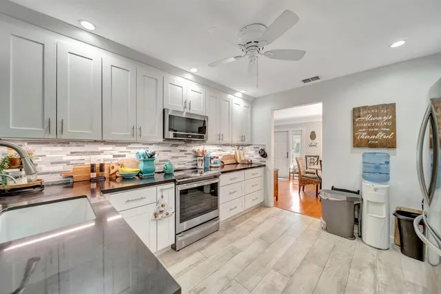 a kitchen with stainless steel appliances granite countertop a refrigerator and a stove top oven