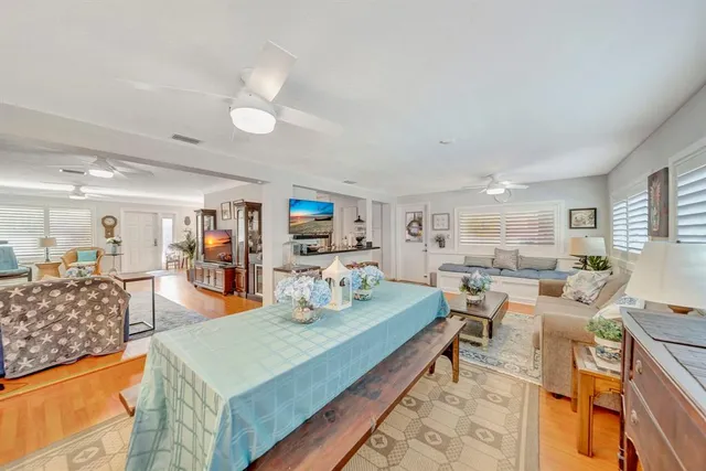 a kitchen with stainless steel appliances kitchen island granite countertop a table chairs and a refrigerator