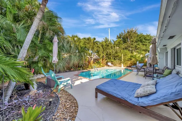 a view of swimming pool with outdoor seating and plants