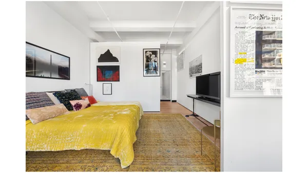 a bedroom with a bed a couch and a window