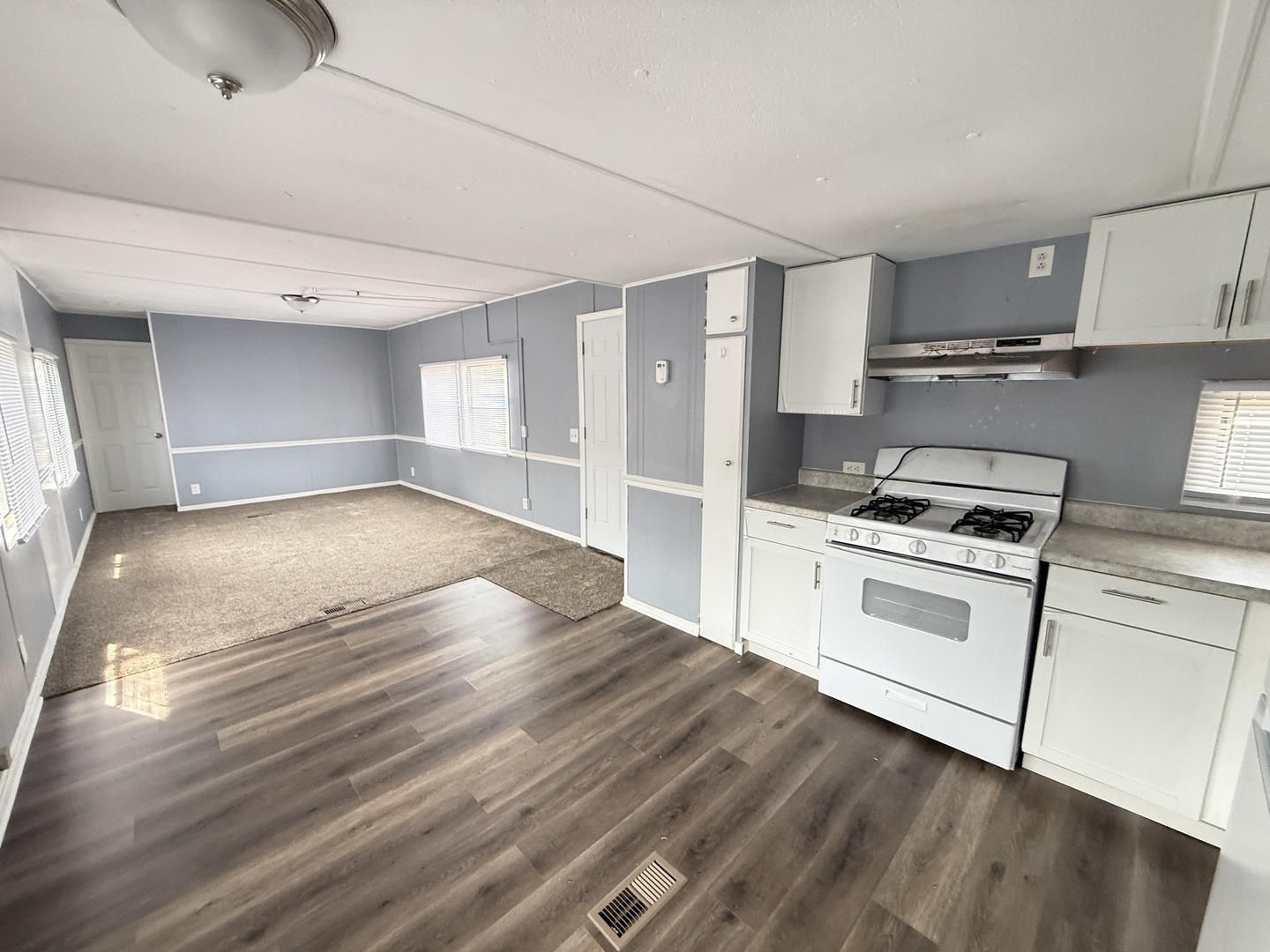 1712 South Dixie Highway, Unit 272 Crete, IL 60417 - Photo 7 of 12 a kitchen with granite countertop a stove cabinets and wooden floor