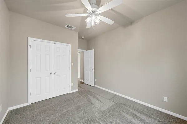an empty room with a ceiling fan and a fan