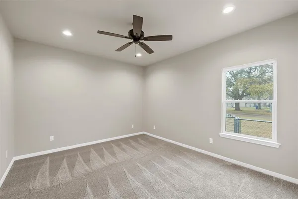 an empty room with a window and a ceiling fan