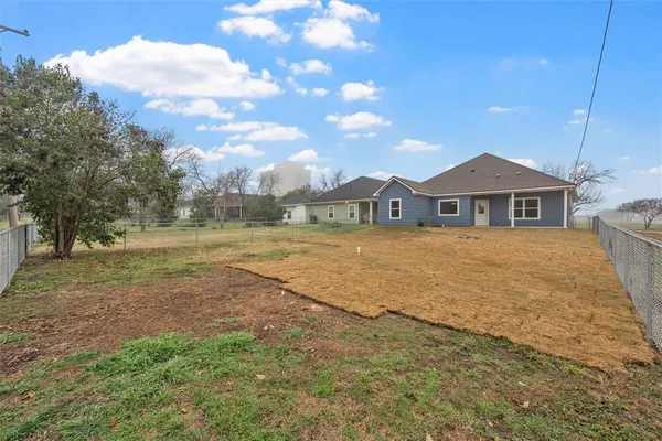 a view of an house with backyard and trees