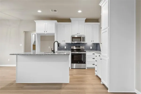 a kitchen with stainless steel appliances a refrigerator stove and microwave