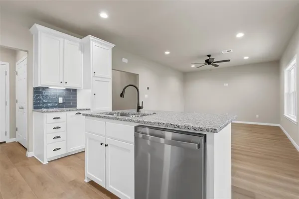 a kitchen with granite countertop a sink and cabinets