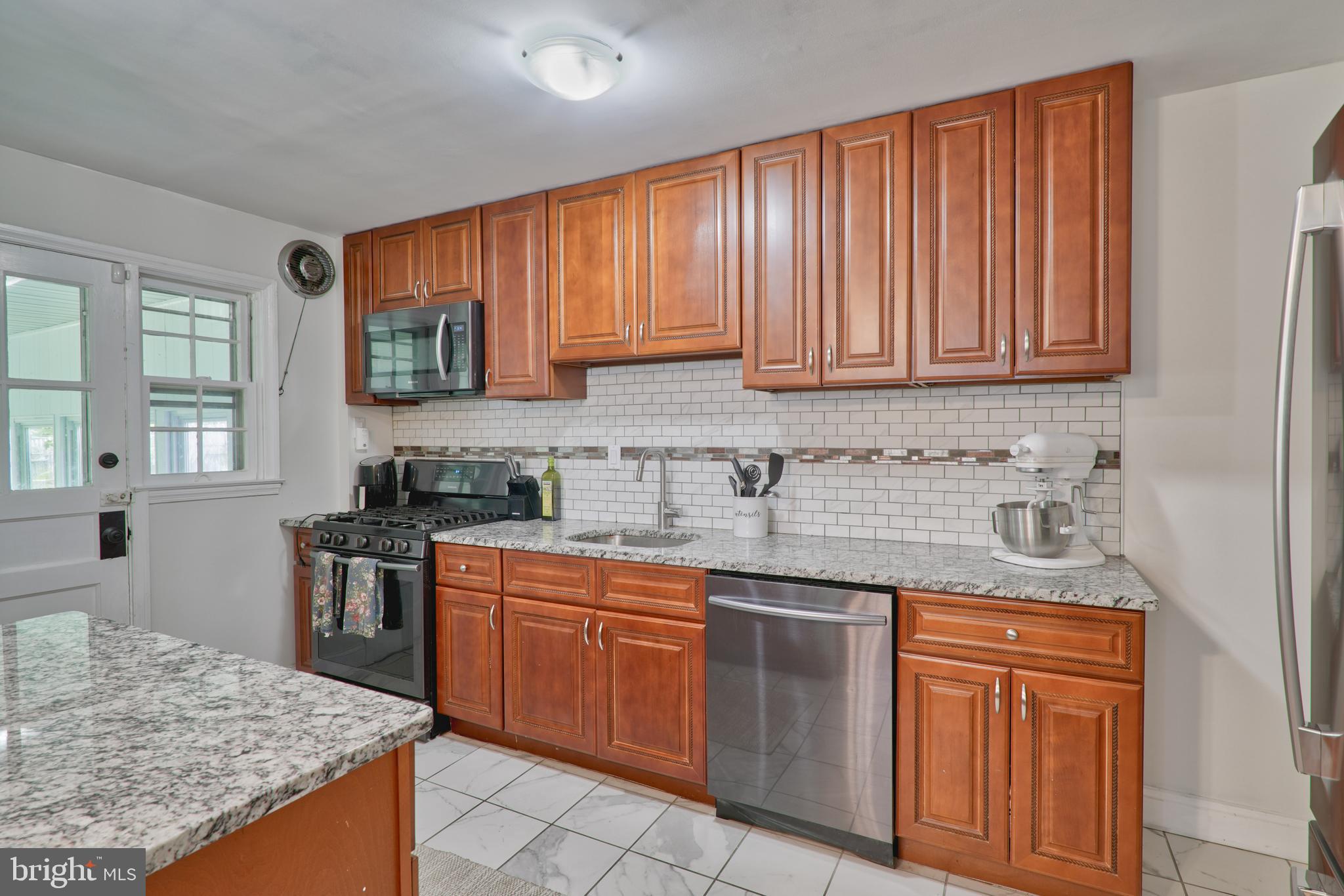 a kitchen with stainless steel appliances granite countertop wooden cabinets a sink and dishwasher