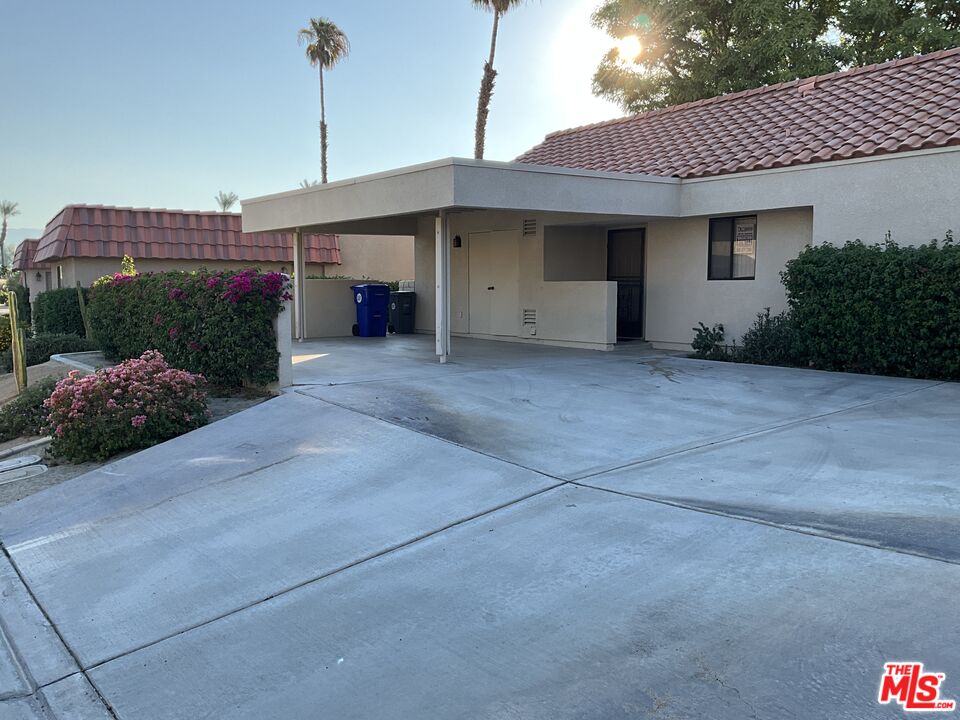 41726 Resorter Boulevard, Unit 516 Palm Desert, CA 92211 - Photo 1 of 17 a front view of a house with a garage and lake view