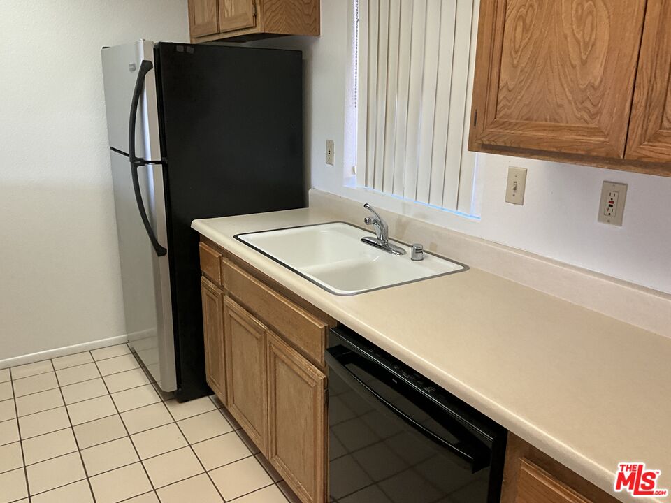 41726 Resorter Boulevard, Unit 516 Palm Desert, CA 92211 - Photo 5 of 17 a kitchen with a sink and a refrigerator