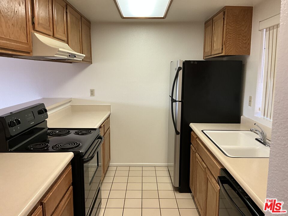 41726 Resorter Boulevard, Unit 516 Palm Desert, CA 92211 - Photo 6 of 17 a kitchen with a sink stove and refrigerator
