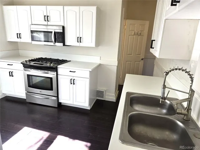 a kitchen with a sink and a stove top oven
