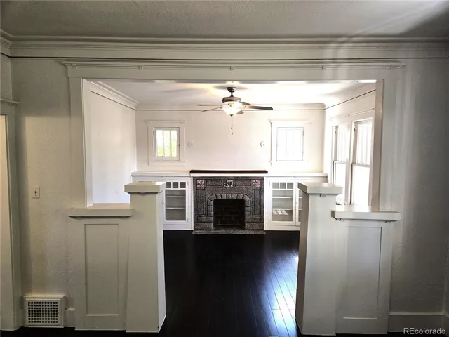 a view of a livingroom with a fireplace wooden floor and window