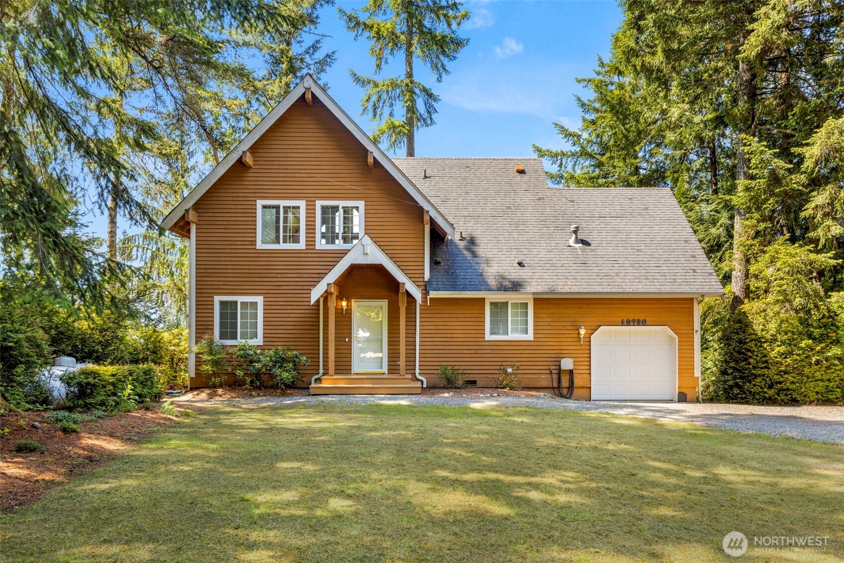 19736 Northwest Stavis Bay Road Seabeck, WA 98380 - Photo 2 of 39 a front view of a house with a garden and plants
