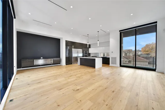 a large kitchen with stainless steel appliances kitchen island a large counter top and a refrigerator