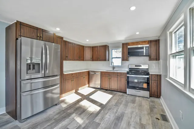 a kitchen with granite countertop stainless steel appliances and wooden cabinets