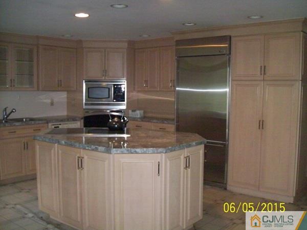 797 New Durham Road Edison, NJ 08817 - Photo 8 of 24 a kitchen with stainless steel appliances granite countertop a refrigerator a stove and a sink with wooden cabinets