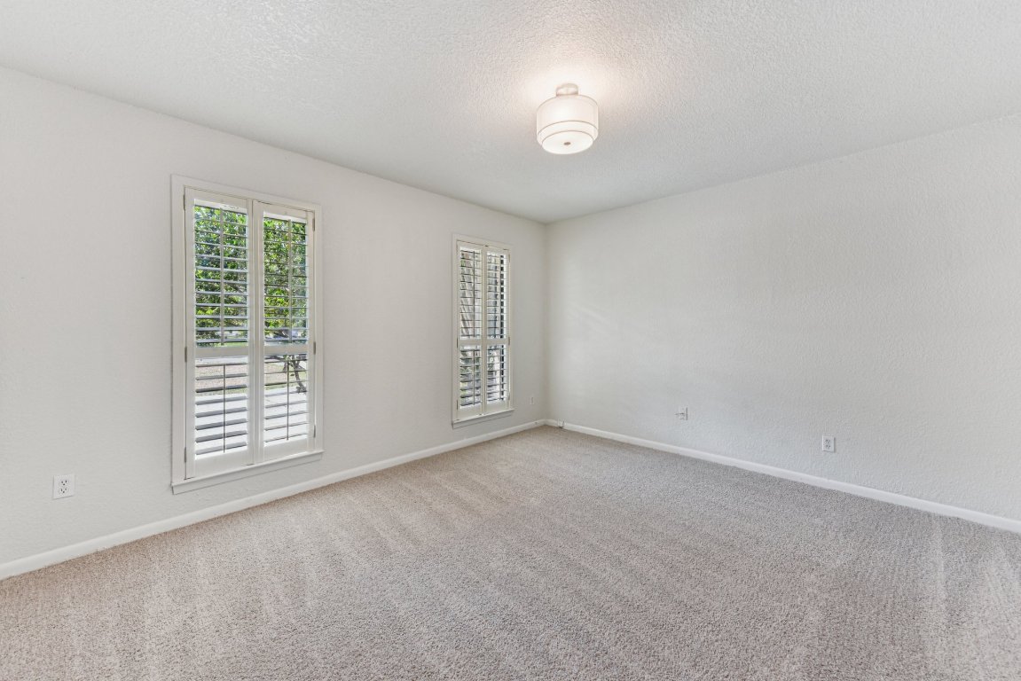 503 Hackberry Street Lockhart, TX 78644 - Photo 25 of 36 Empty room featuring carpet floors and a textured ceiling