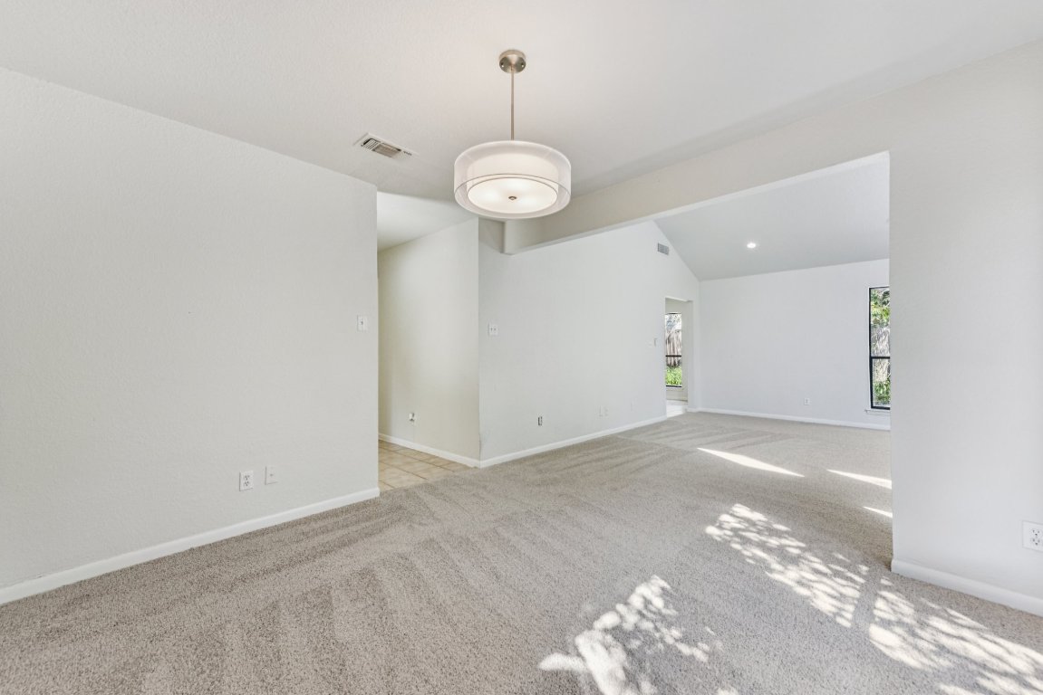 503 Hackberry Street Lockhart, TX 78644 - Photo 9 of 36 Unfurnished living room featuring lofted ceiling and light carpet