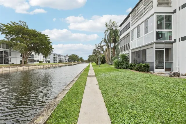 a view of a lake with a yard and large trees