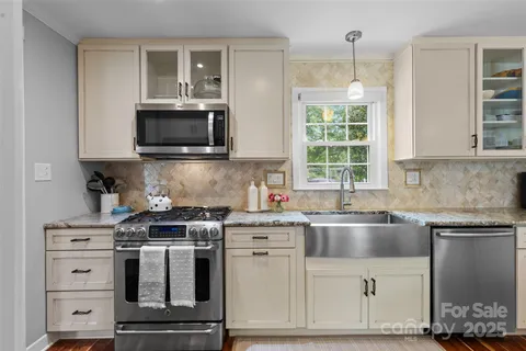 a kitchen with cabinets appliances a sink and a window
