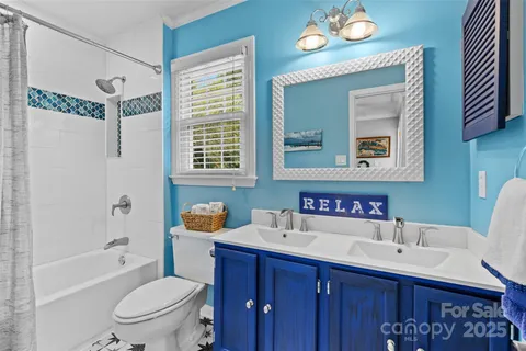 a bathroom with a toilet a sink a tub and a mirror