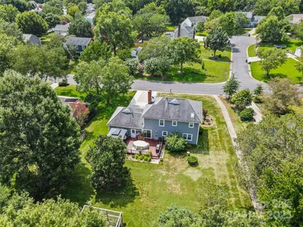 an aerial view of a house with swimming pool and garden