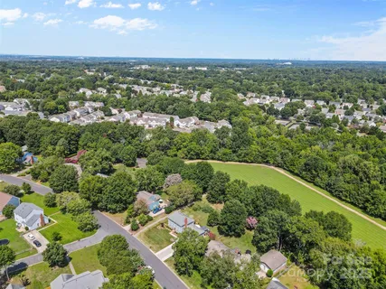 an aerial view of residential houses with outdoor space and trees
