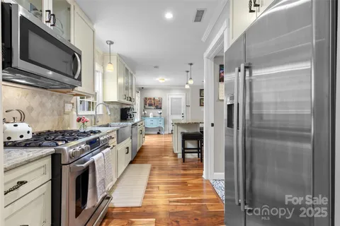 a kitchen with stainless steel appliances granite countertop a stove a refrigerator and a stove