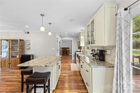a kitchen with stainless steel appliances kitchen island granite countertop a refrigerator and a stove top oven
