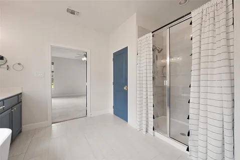 a bathroom with a shower and a glass door