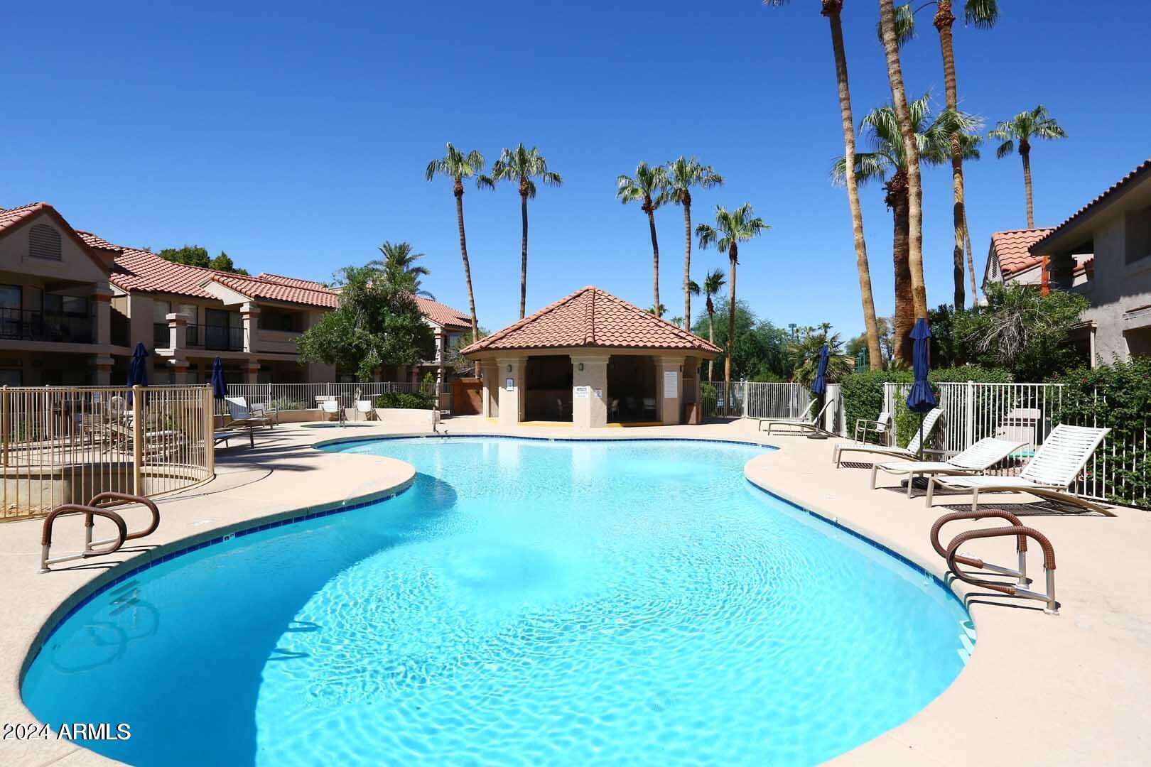 9705 East Mountain View Road, Unit 1021 Scottsdale, AZ 85258 - Photo 12 of 14 a view of a swimming pool with chairs