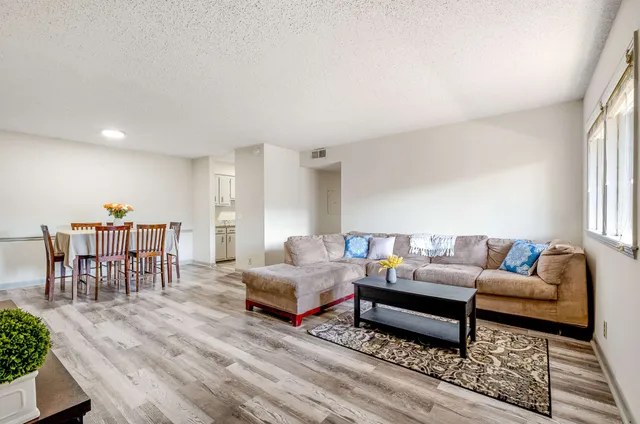 a living room with furniture and a wooden floor
