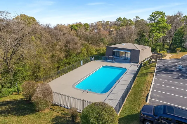 a view of a tennis ground with large trees