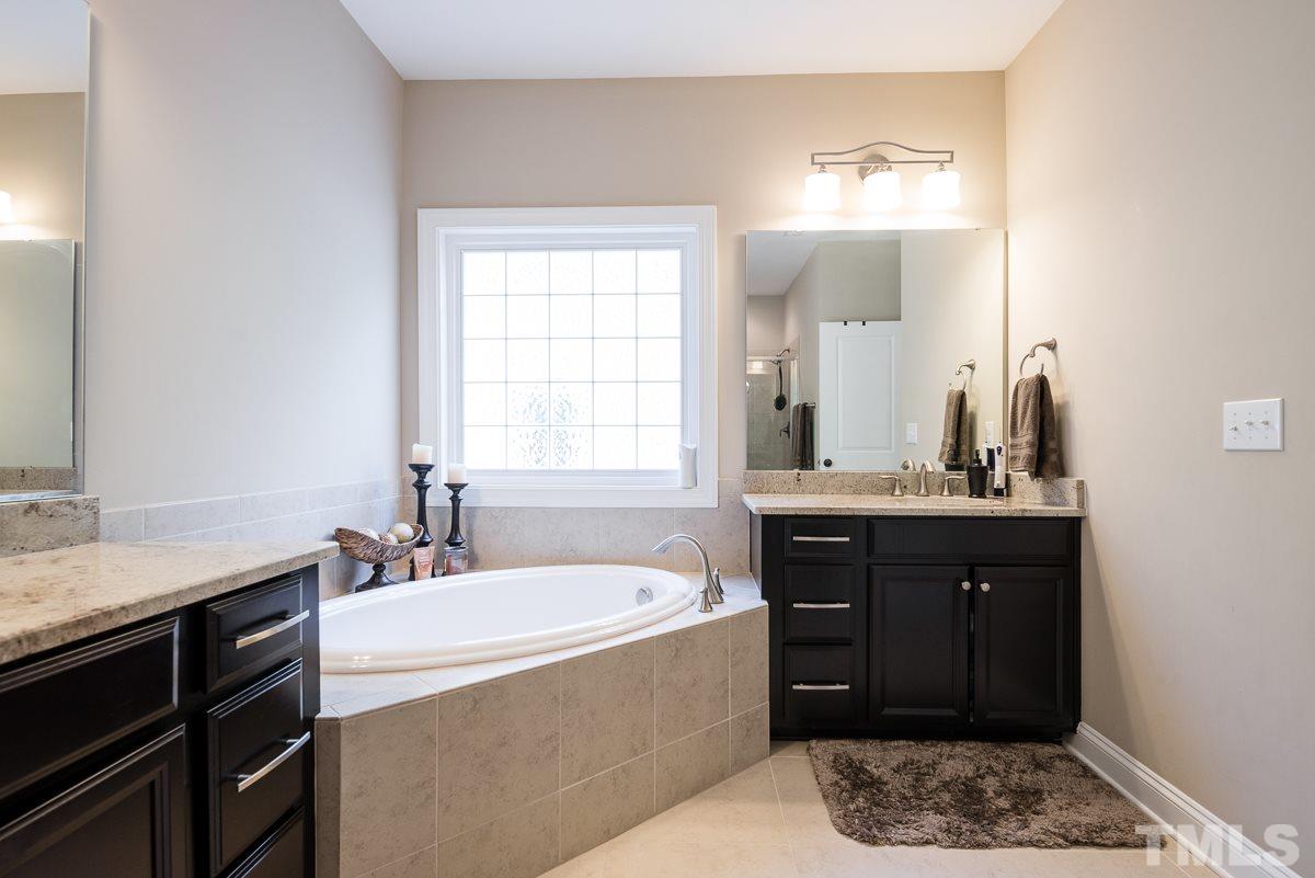 4025 Periwinkle Blue Lane Raleigh, NC 27612 - Photo 14 of 23 a spacious bathroom with a tub a sink and mirror