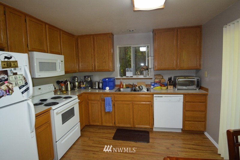20607 West Richmond Road Bothell, WA 98021 - Photo 3 of 16 a kitchen with granite countertop a sink cabinets and stainless steel appliances