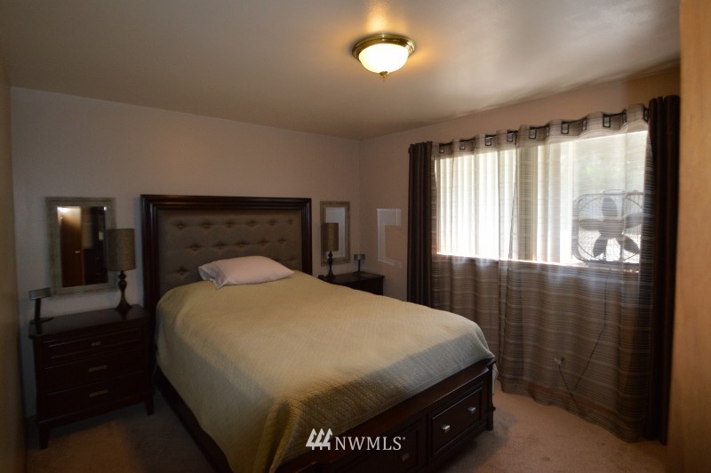 20607 West Richmond Road Bothell, WA 98021 - Photo 7 of 16 a bed sitting in a bedroom next to a window