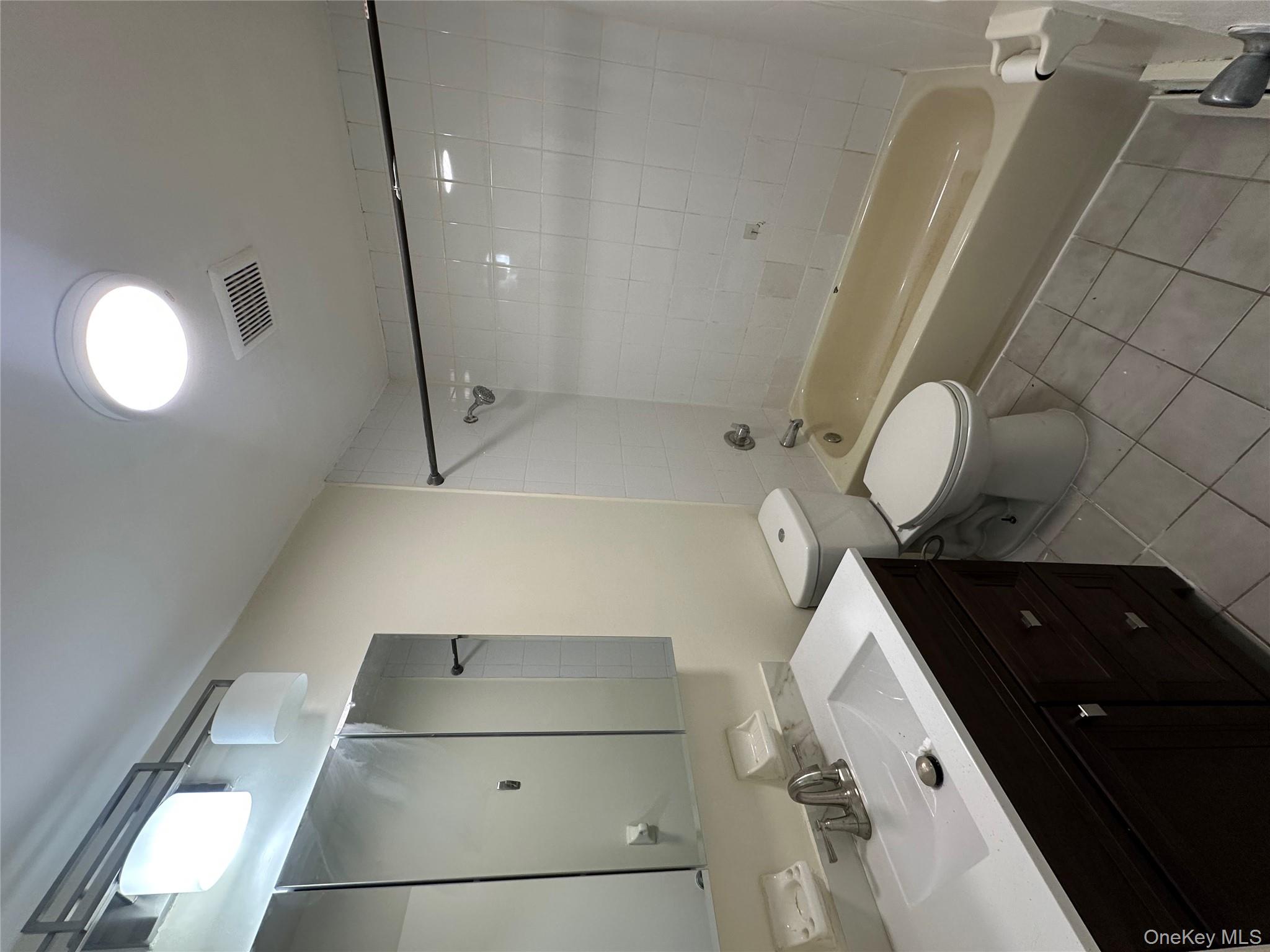 987 Lincoln Avenue, Unit 2 Brooklyn, NY 11208 - Photo 3 of 7 a bathroom with a double vanity sink toilet and shower