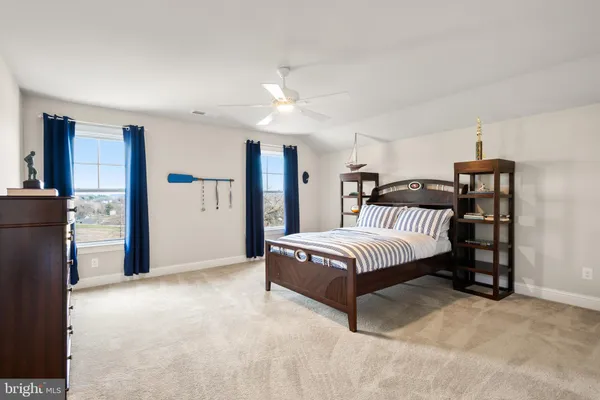 a spacious bedroom with a bed a couch and a large window