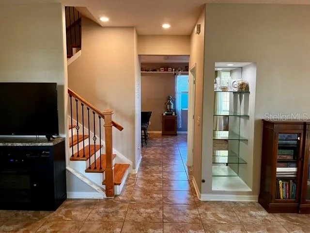 a view of a hallway with wooden floor windows and a kitchen space