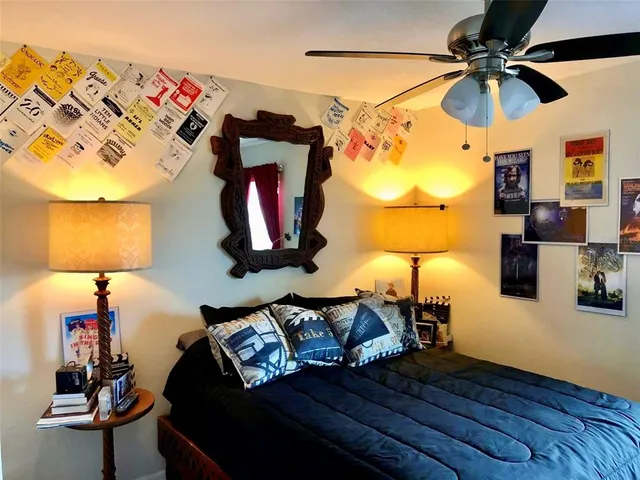a bedroom with a bed and a lamp on the dresser
