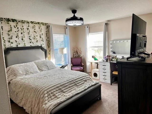 a bedroom with a large bed and a window