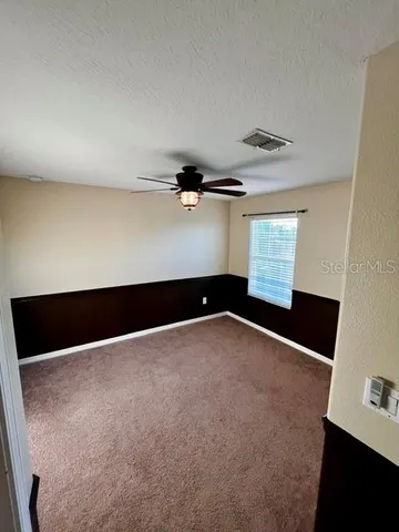 a bathroom with a granite countertop toilet sink and mirror