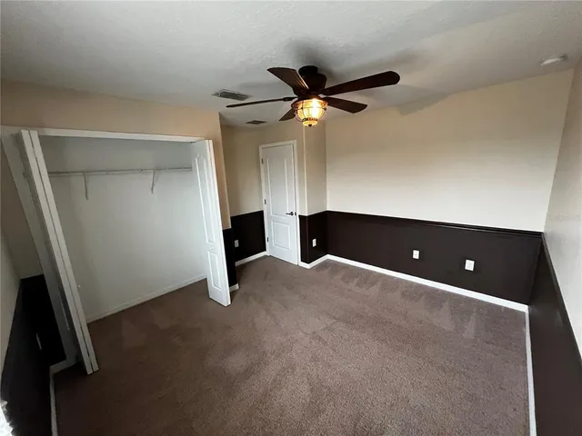 a bathroom with a granite countertop toilet sink and mirror