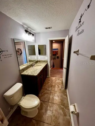 a large bathroom with a granite countertop sink a large mirror and a bathtub