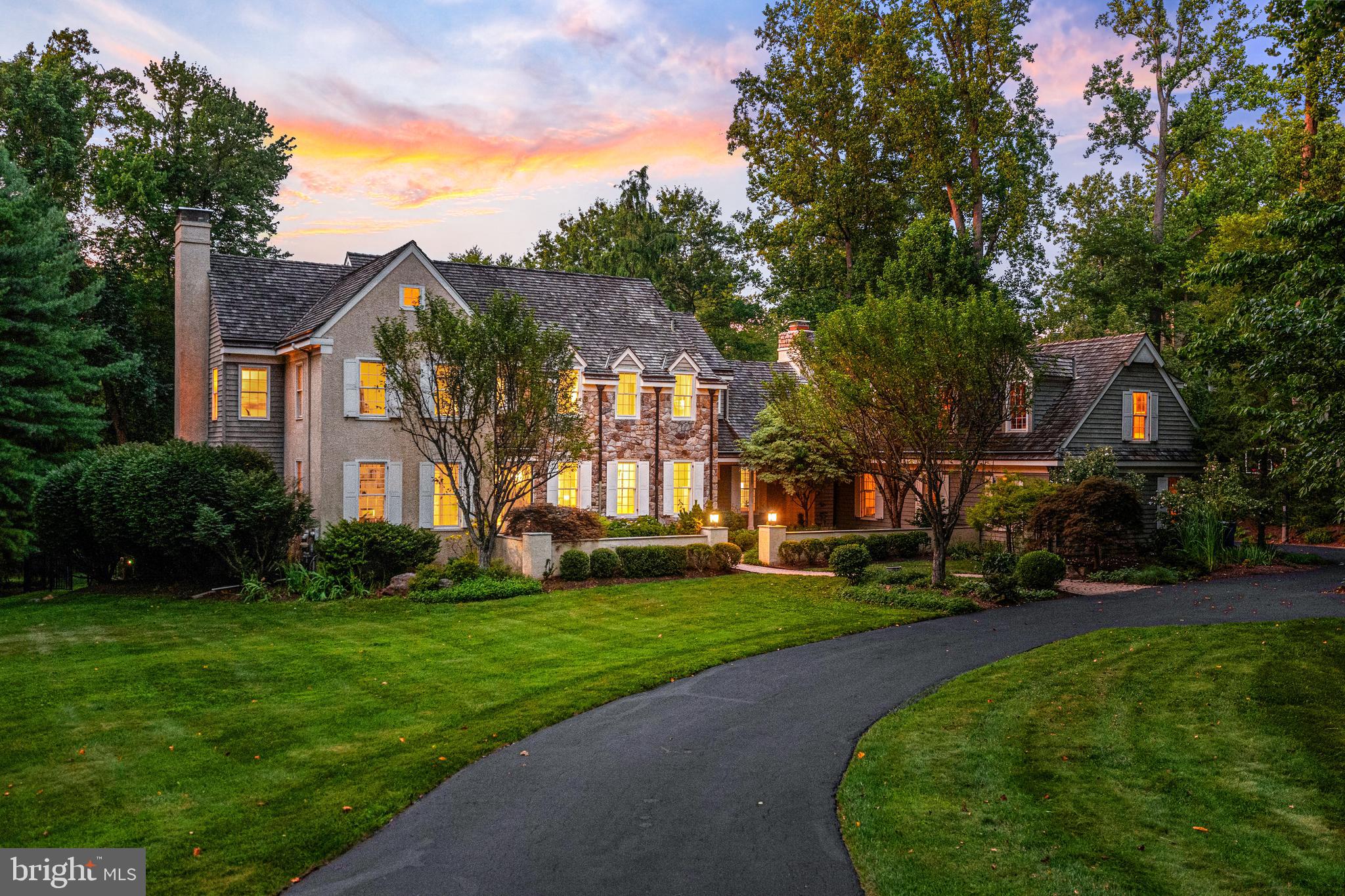a front view of a house with a yard and trees