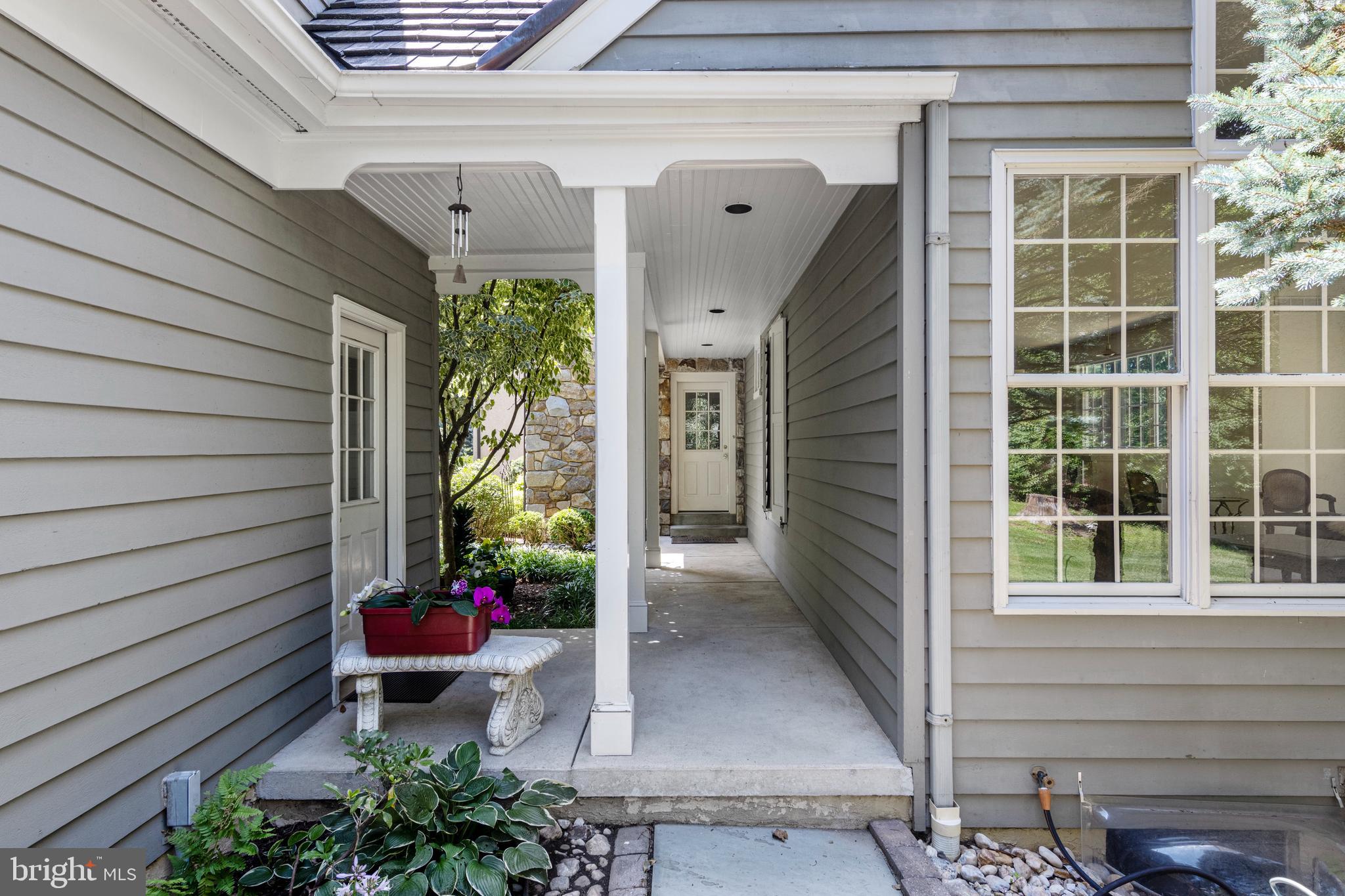 1285 Farm Road Berwyn, PA 19312 - Photo 8 of 75 a view of a porch with chairs and potted plants next to a yard