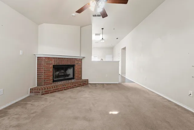 an empty room with a fireplace and fan